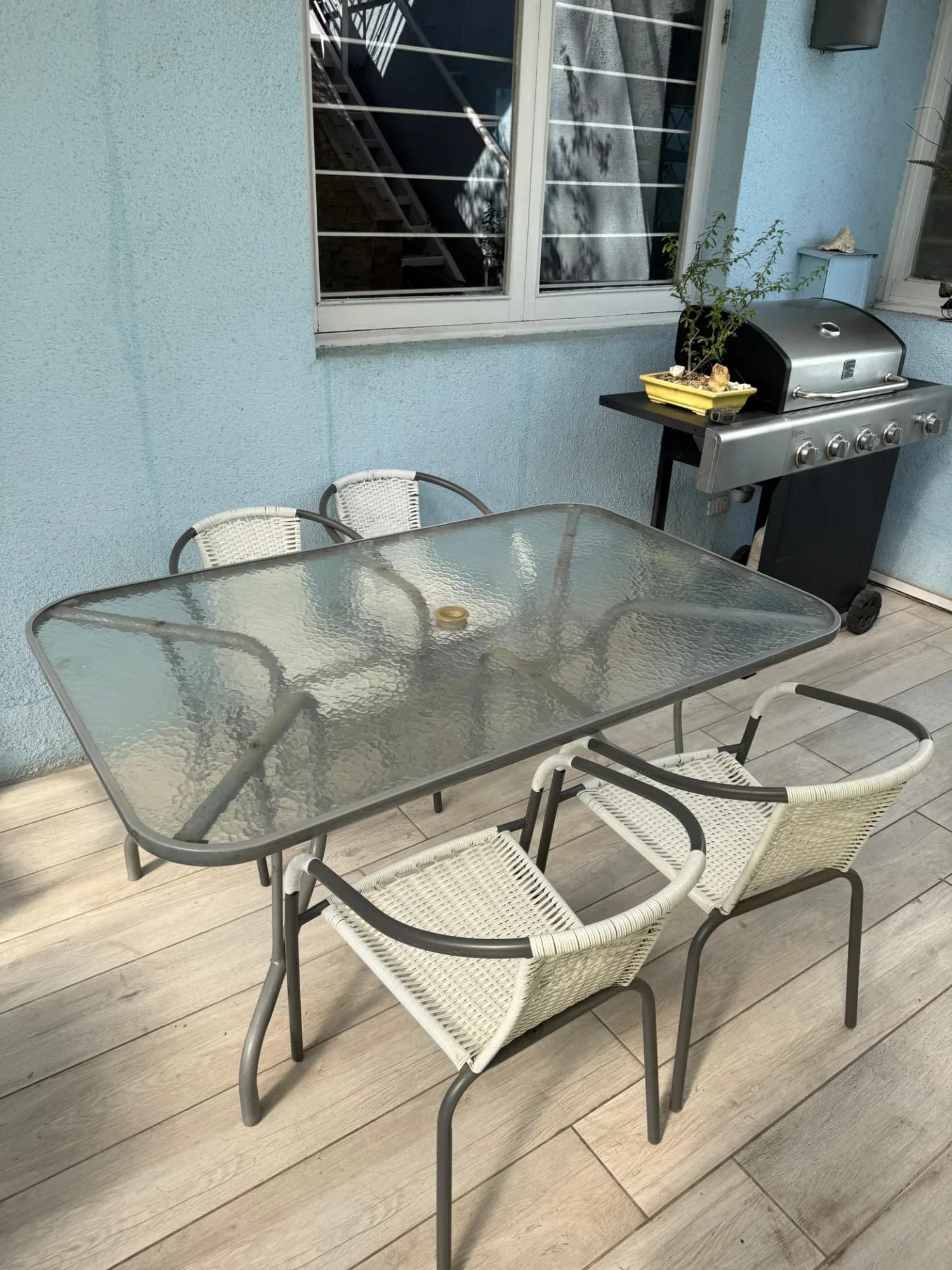 Mesa de terraza con vidrio templado y 4 sillas.