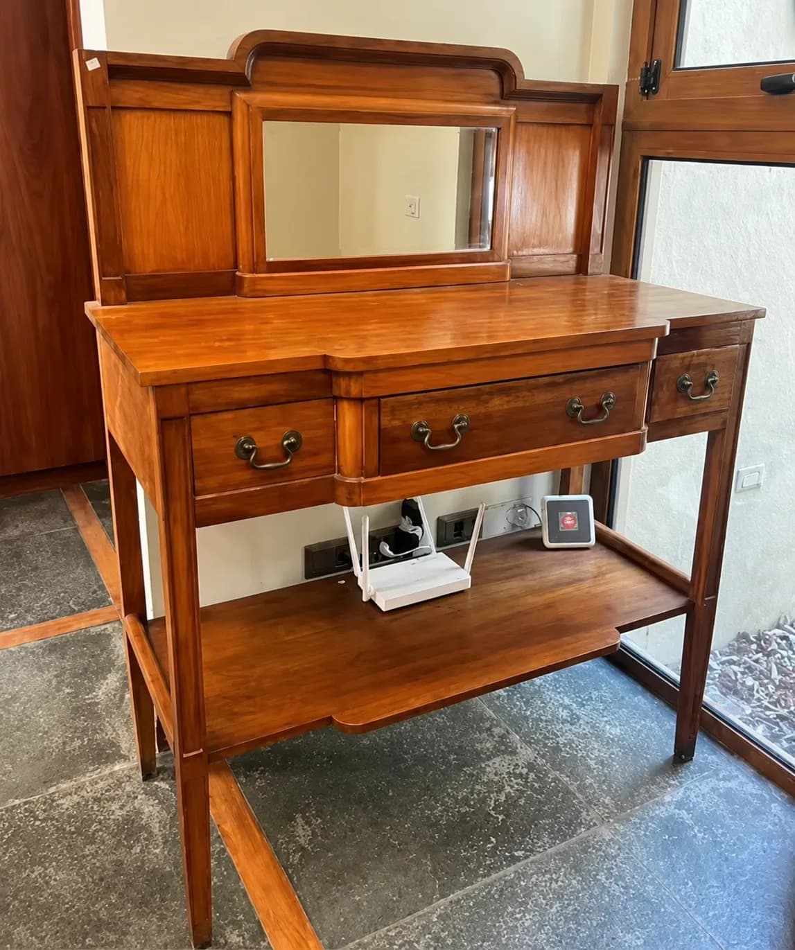 Mueble de madera lingue y espejo biselado.